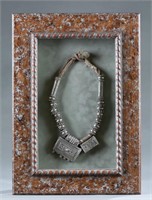 Framed Omani silver Hirz necklace.