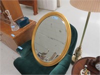 large gold oval framed mirror
