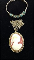 One large gold tone frame cameo and a gold tone