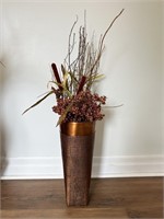 Copper coloured metal pot with faux plants. Pot