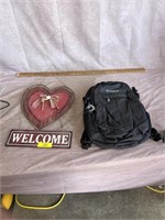 welcome sign and backpack