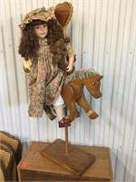 Doll on wooden horse with stand