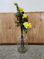 Large glass jug with artificial flowers