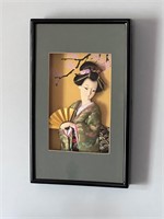 Broken face geisha doll in shadow box