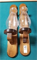 2 wooden wall sconces with glass hurricanes