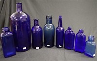 Nine vintage blue glass bottles