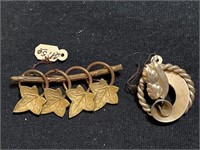 2 vintage gold tone brooches, one has maple