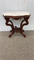 Marble top Victorian walnut table with a carved