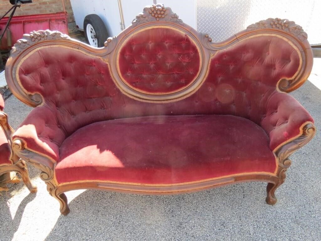 Antique red velvet loveseat couch.