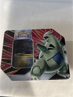 Pokémon tin with a coin and some Pokémon cards