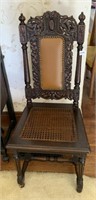 CARVED BACK CHAIR W/ CANE SEAT AND LEATHER BACK