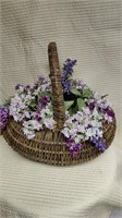 Woven wicker basket with floral arrangement.