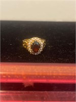 New gold tone ring with ruby colored stone size 6