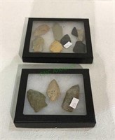 Fossilized arrowheads and display boxes behind