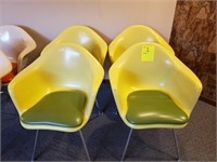 four yellow molded plastic chairs
