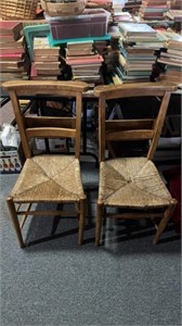 To Antique chairs with book racks in the back,