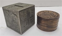 Two small metal coin banks. Stack of pennies and