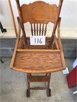 High chair on wheels; wicker seat, carved back