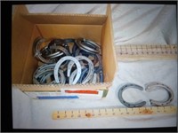 Box full of small metal horse shoes