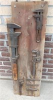 Collection of monkey wrenches on barn board