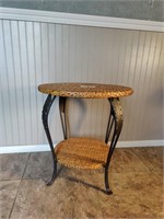 2 tier wicker end table with metal legs.