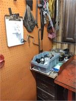 Tools on wall and wood cabinet with contents.