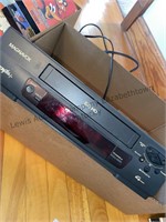 Magnavox VHS player and box of VHS tapes and