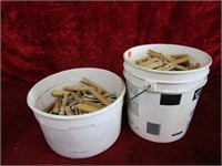 (2)pails of old wood clothes pins.
