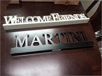 Wooden signs.  "Welcome friends" and "Martini"