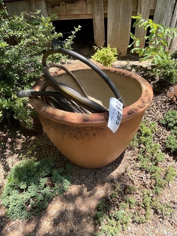 Large clay pot with garden hose