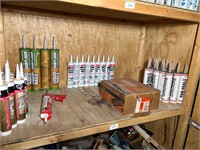 SHELF OF MISC CAULK AND BOX OF STAPLES