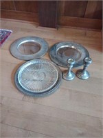 Lot of silver platters and candlestick holders.
