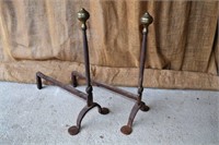 Old forged andirons with brass finial and rosette