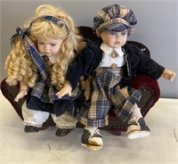 PORCELAIN GIRL AND BOY DOLL SITTING ON LOVESEAT