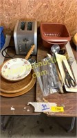 Silverware, wooden plates, toaster, utensils