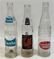 THREE VINTAGE GLASS SODA BOTTLES WITH GRAPHICS