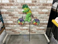 Frog riding bicycle yard art
