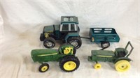 Three green toy tractors