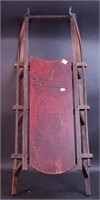 A vintage child's sled with original red painted