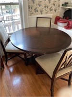 Round dining room table with three chairs