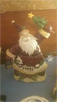 Santa figure holding holiday tree