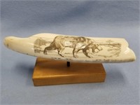 Juvenile walrus tusk with a scrimshaw of a saber t