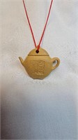 SMALL CLAY POTTERY TEAPOT PENDANT ON RED ROPE