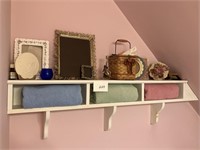 Various decrative  items with towels on shelf