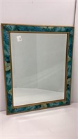 Mirror with teal color design around border,