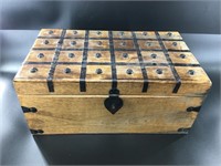 Wooden chest with metal detailing on top and corne