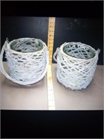 2 hanging  wicker baskets with glass jars inside