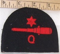 FELT PATCH WITH STAR OVER CANNON OVER "Q"