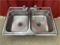 Stainless steel double kitchen sink. Shows some
