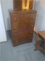 4 drawer wooden dresser on caster wheels.